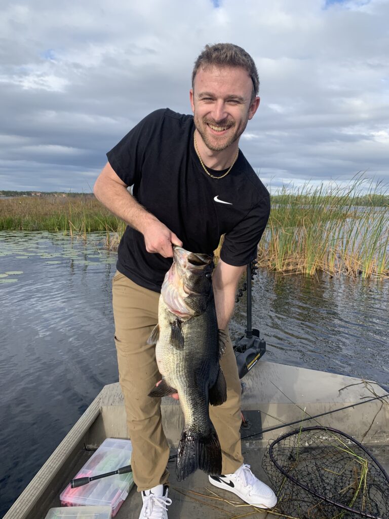 Man holding large fish on lake boat.