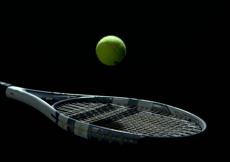 A striking tennis ball and racket image on a dark background, capturing motion and sport essence.