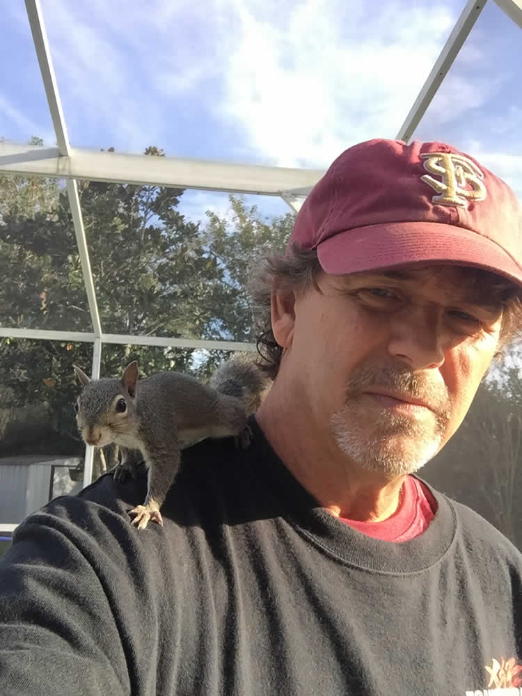 Man with a squirrel perched on his shoulder.