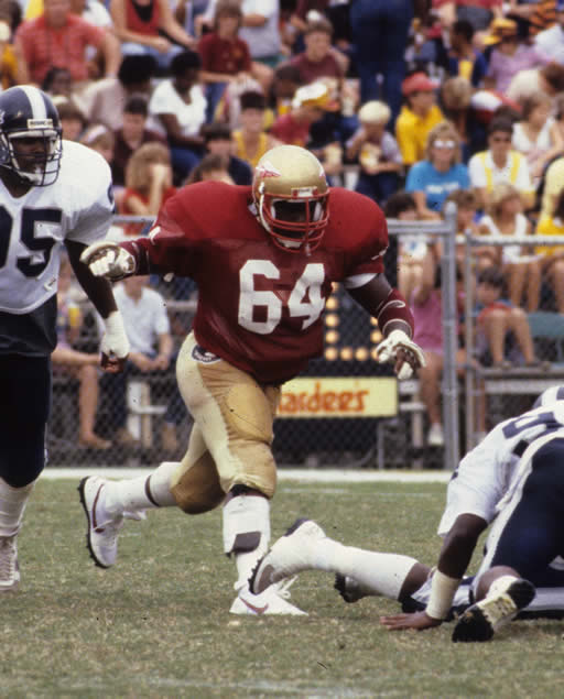 Football player in red jersey running on field.