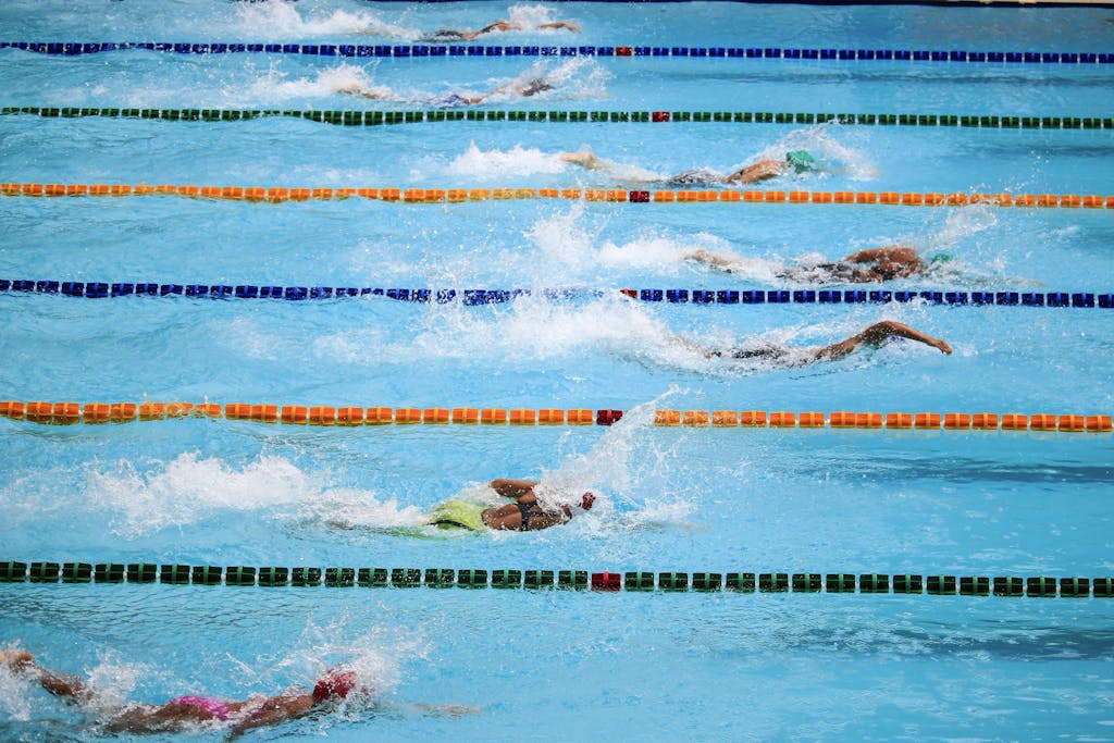 Swimmers compete in an outdoor pool race, showcasing athleticism and sportsmanship.